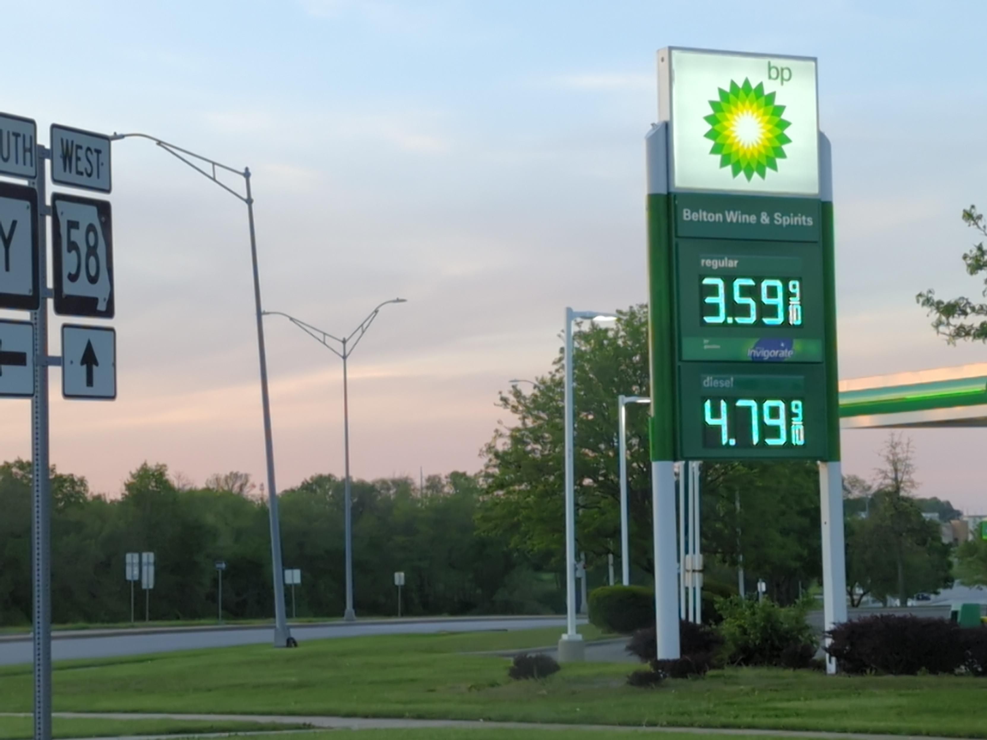 Alt text: A BP gas station price sign beside a roadside with trees and a dusk sky; the sign shows regular gas priced at $3.59 and diesel at $4.79, with highway directional signs (US 58) visible on the left.